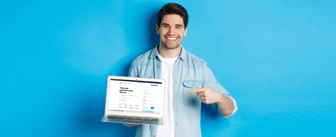 Homem sorridente com laptop na mão aprontando para o site da eTraduções
