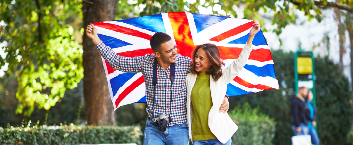 Casal jovem e feliz de turistas com a bandeira do Reino Unido