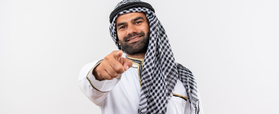Homem árabe sorrindo e apontando com o dedo