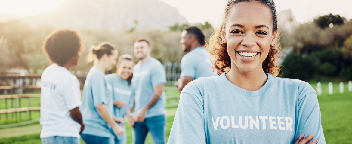 Mulher voluntária sorrindo com sua equipe