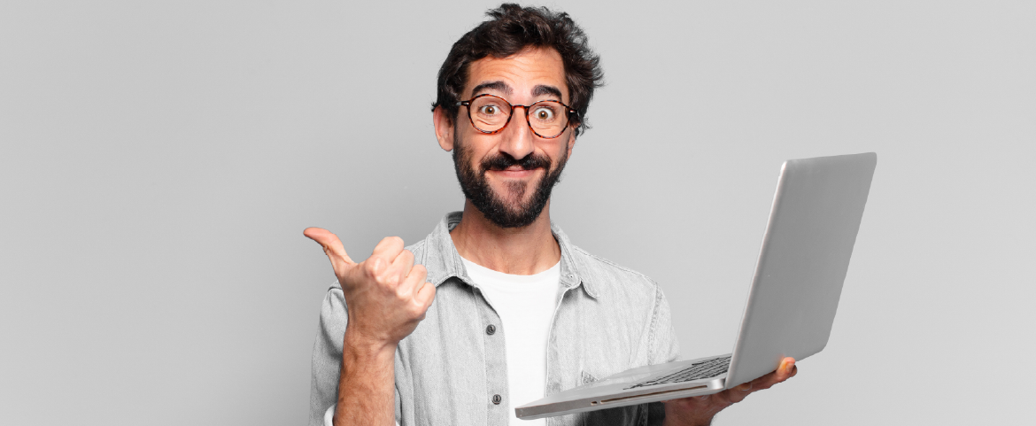 Homem de barba usando óculos de grau segurando laptop Homem de barba usando óculos de grau segurando laptop