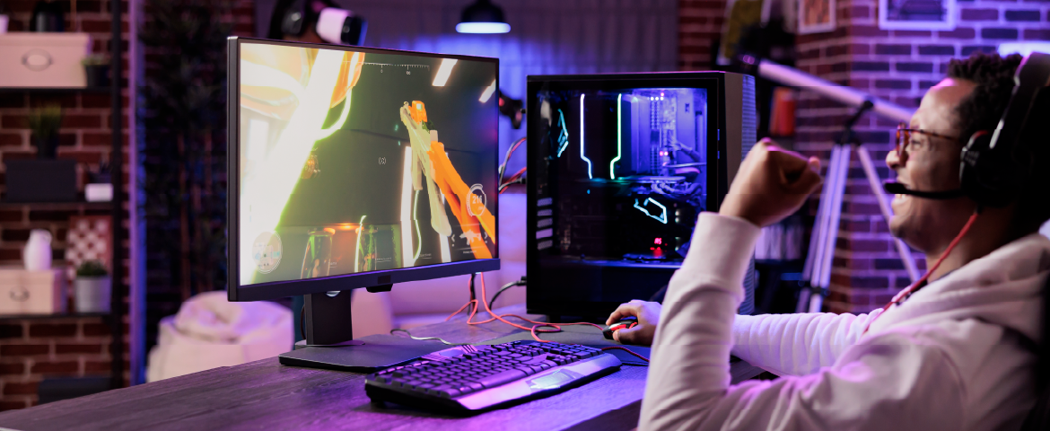 Homem em mesa com desktop comemorando
