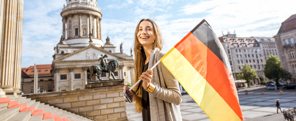 Mulher turistando em Berlim, com a bandeira do país Mulher turistando em Berlim, com a bandeira do país