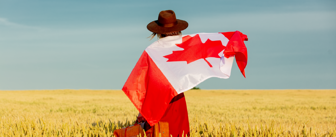 Mulher de costas com bandeira do Canadá Mulher de chapéu, costas, segurando uma mala e com bandeira do Canadá nas costas