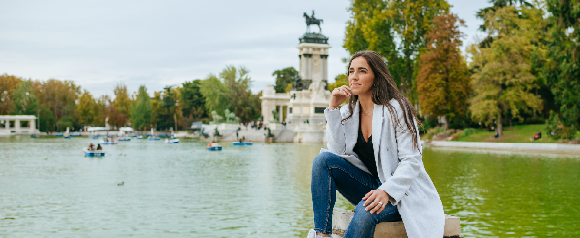 Empresária relaxando no Parque do Retiro em Madri, apreciando a vista do lago Empresária relaxando no Parque do Retiro em Madri, apreciando a vista do lago