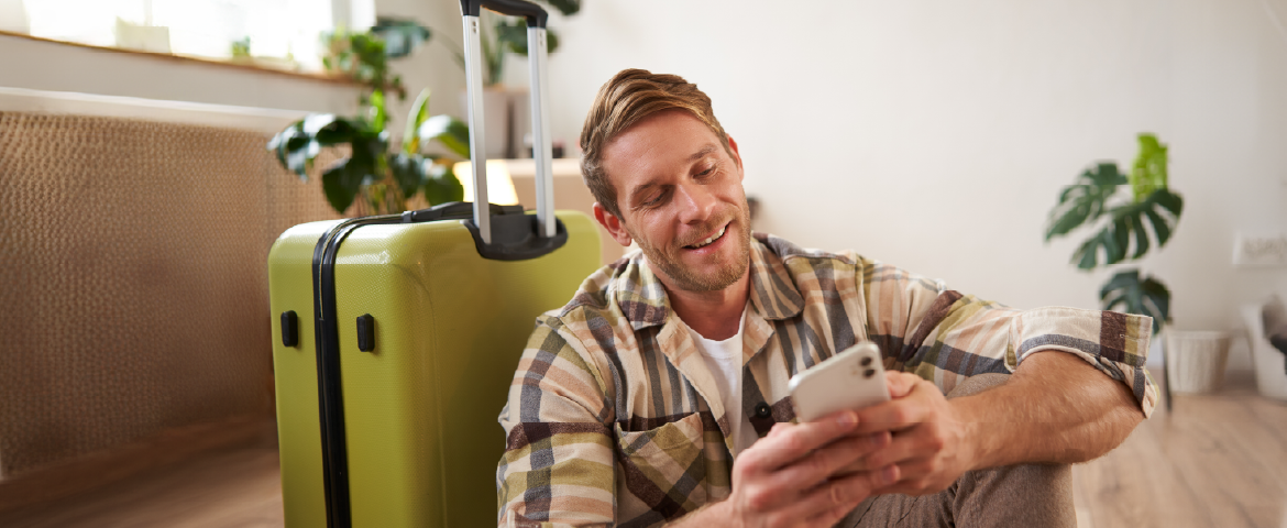 Homem nômade digital mexendo celular Homem nômade digital vestindo camisa xadrez mexendo celular