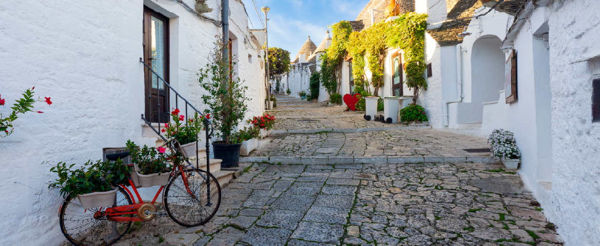 Pequeno vilarejo italiano com calçadas de pedra e uma bicicleta vermelha ao lado de uma casa. Pequeno vilarejo italiano com ruas de pedra e uma bicicleta vermelha ao lado de uma casa.
