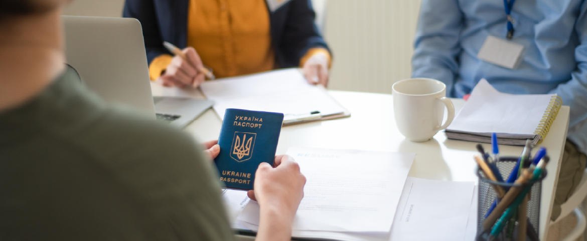 Imigrante ucraniano com passaporte em mãos.