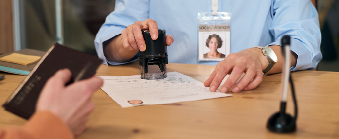 Agente alfandegário carimbando formulário de visto para turista.