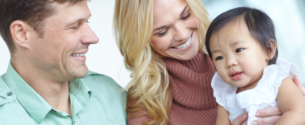 Casal feliz com uma menina bebê asiática